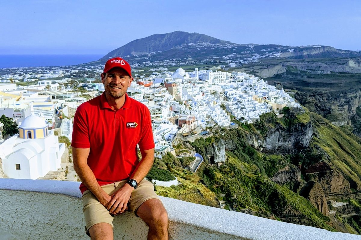 Best of Greece tour review author sitting in front of view of Fira, Santorini