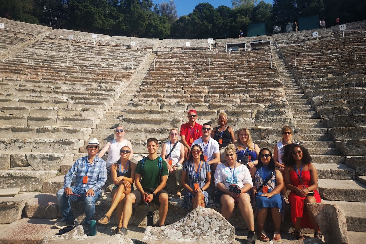 Best of Greece tour group sitting in Epidaurus ancient theatre