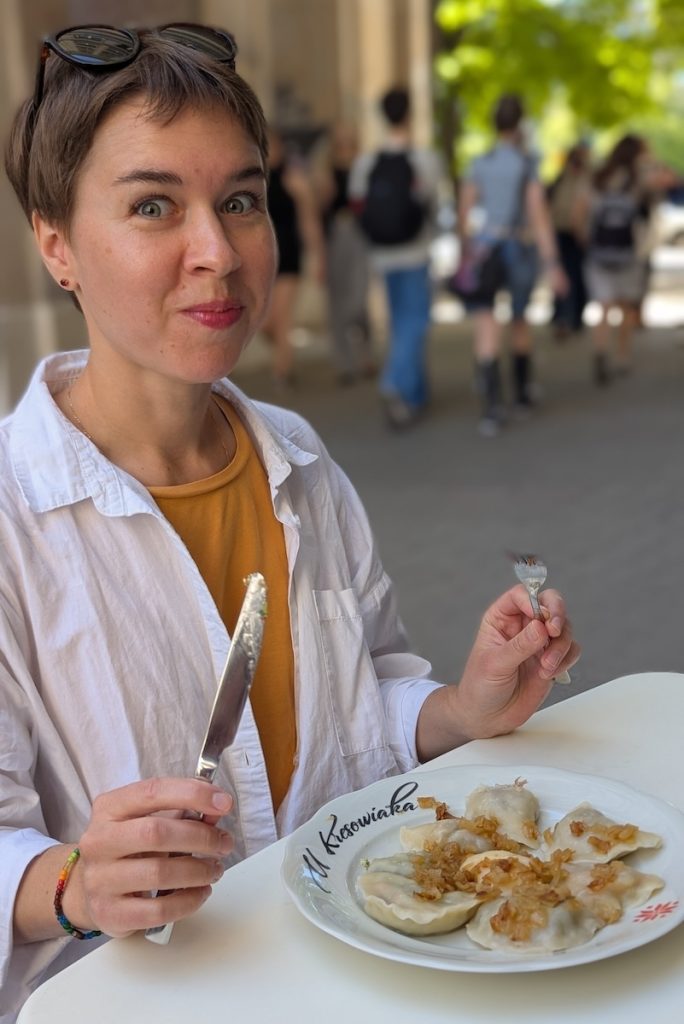 Poland travel guide featuring someone enjoying Pierogi