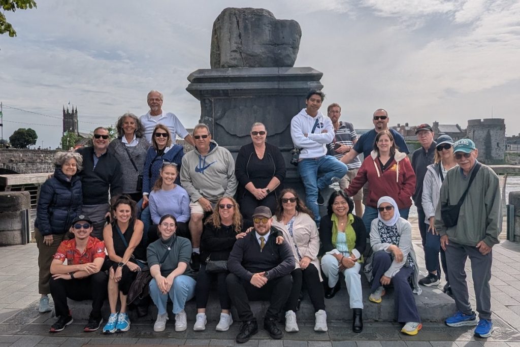 Best of UK & Ireland tour review - Expat Explore group posing with the Limerick Treaty Stone