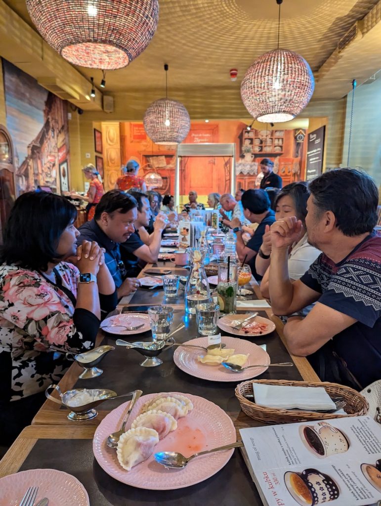 Poland travel guide featuring a tour group dining at Zapiecek for Pierogi
