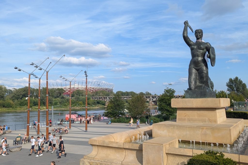 Warsaw Travel Guide - View of the Vistula River with mermaid statue and stadium