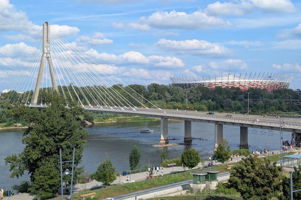 View of the Vistula River from the Copernicus Science Centre rooftop capturing Świętokrzyski Bridge and National Stadium